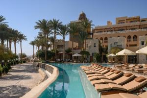 a swimming pool with lounge chairs and a hotel at The Makadi Spa Hotel - Couples Only 18 Years Plus in Hurghada