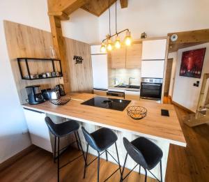 a kitchen with a counter with chairs around it at Chalet Adele - Appartement 6 personnes situé en bord de piste St Martin de Belleville MAE-8204 in Saint-Martin-de-Belleville