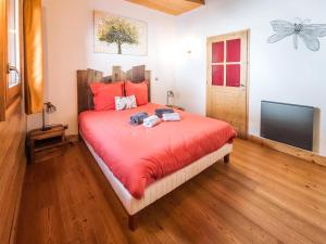 a bedroom with a bed with red sheets and a flat screen tv at Chalet Adele - Appartement 6 personnes situé en bord de piste St Martin de Belleville MAE-8204 in Saint-Martin-de-Belleville