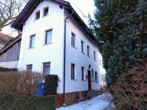 a white house with snow in front of it at Ferienhaus Waldkrone in Arrach