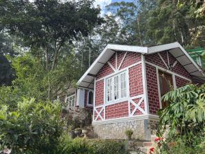 a red brick house with a white window at The Woodside Manor in Nuwara Eliya