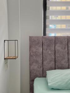 a headboard of a bed in a room with a window at SeaStep Apartment Golem in Golem
