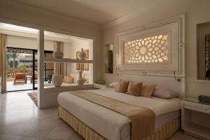 a bedroom with a large bed and a balcony at The Makadi Spa Hotel - Couples Only 18 Years Plus in Hurghada +60 photos