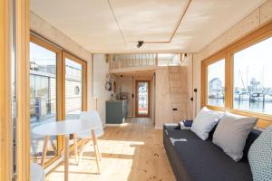 a living room with a couch and a table at Hausboot Alma in Schleswig +7 photos