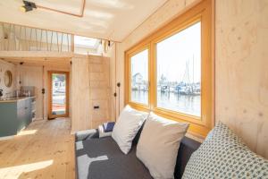 a living room with a couch and a large window at Hausboot Alma in Schleswig