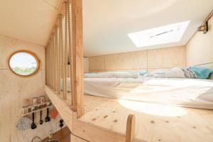 a bedroom with a bed in a tiny house at Hausboot Alma in Schleswig