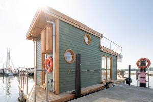 a tiny house on a dock on the water at Hausboot Alma in Schleswig