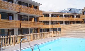 a hotel with a swimming pool in front of a building at Hotel Planai by Alpeffect Hotels in Schladming