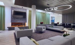 a living room with a couch and a fireplace at Hotel Planai by Alpeffect Hotels in Schladming