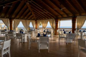 a dining room with white chairs and tables at The Makadi Spa Hotel - Couples Only 18 Years Plus in Hurghada