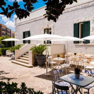 an outdoor patio with tables and chairs and umbrellas at Villa Aurelia Suites and Apartments in Locorotondo