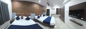 una camera da letto con due letti con cuscini blu e bianchi di Hotel New Rest Inn a Mahesāna