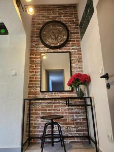 a brick wall with a mirror and a stool at Studio Nessa with a private jacuzzi in Krk
