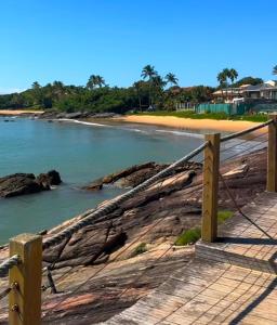 a wooden boardwalk on a beach with the ocean at Ambiente familhiar in Guarapari