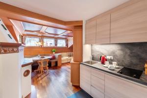 a kitchen with wooden cabinets and a dining room at Alpenhof Lodge in Saltusio