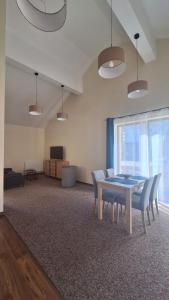 a dining room with a table and chairs in a room at Skalnica- apartamenty z widokiem na góry, przy szlakach in Karpacz