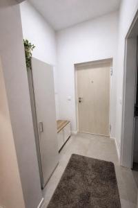 an empty hallway with a door and a rug at Ilma Apartmani Musique in Tuzla