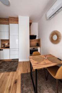 a kitchen with a table and chairs in a room at Ilma Apartmani Musique in Tuzla