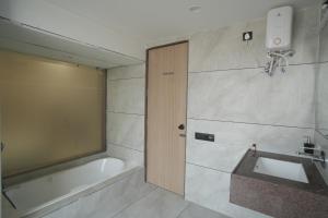 a bathroom with a sink and a bath tub at Mahadev Hotel in Botād