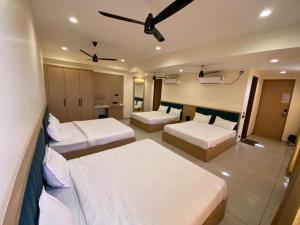 a hotel room with two beds and a ceiling at Mahadev Hotel in Botād