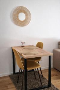 a wooden table with yellow chairs and a mirror at Ilma Apartmani Musique in Tuzla +2 photos