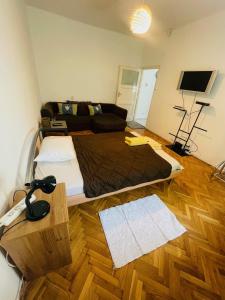a bedroom with a bed and a couch in it at Downtown Apartman near City Center & Miskolc Plaza in Miskolc