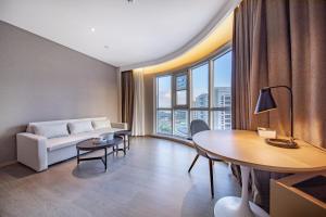 a living room with a couch and a table at Atour Hotel Rizhao Dongyi Town in Rizhao +31 photos