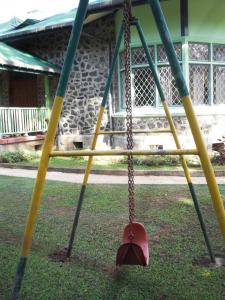 un'altalena in un parco giochi con pali gialli e verdi di Morris Bungalow a Passara