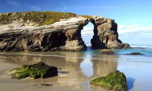 an arch in the sand on a beach at Paraiso Spa Reinante in San Miguel de Reinante