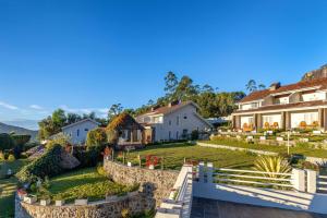 a house with a stone fence and a yard at The Siena Village in Chinnakanal