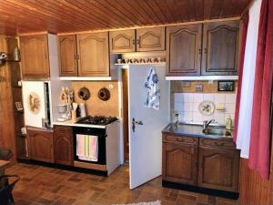 a kitchen with wooden cabinets and a white refrigerator at Ferienhaus Waldkrone in Arrach +7 photos