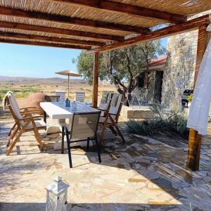 a patio with a table and chairs on a stone patio at Paliokaliva Home in Roussopoúlion