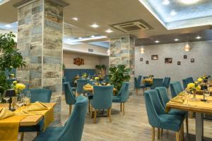 a dining room with tables and blue chairs at SPA Hotel Infinity Park Velingrad in Velingrad