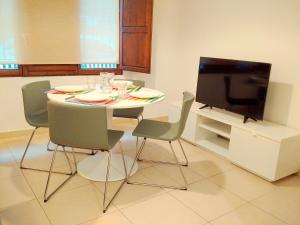uma sala de jantar com uma mesa com cadeiras e uma televisão em Quart Silence em Valência