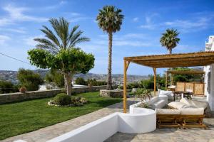 a patio with a gazebo and palm trees at Azula Luxury Apartments in Parikia