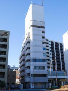 a white building with a crane on top of it at 9Stay川崎 in Kawasaki