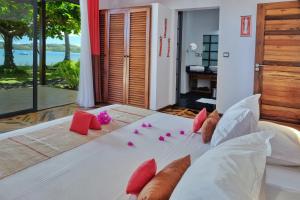 a bedroom with a bed with pink flowers on it at Villa Mora Mora in Nosy Be +13 photos