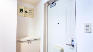 a bathroom with a toilet and a white door at 9Stay川崎 in Kawasaki +121 photos