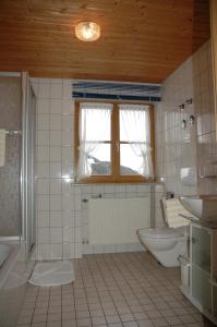 a bathroom with a tub and a toilet and a sink at Landhaus Schmid in Oberstdorf +44 photos