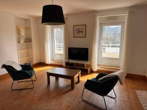 a living room with a table and chairs and a television at L' Annexe Barneville Bourg in Barneville-Carteret