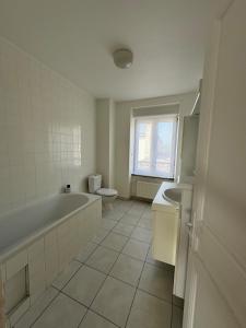 a bathroom with a tub and a toilet and a sink at L' Annexe Barneville Bourg in Barneville-Carteret
