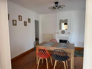 a dining room with a wooden table and chairs at L' Annexe Barneville Bourg in Barneville-Carteret +23 photos