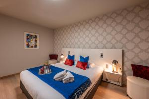 a bedroom with a large bed with blue and red pillows at Hotel Falko in Meise +72 photos