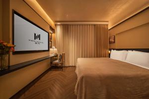a hotel room with a bed and a flat screen tv at PORTAL ART HOTEL in Fengjie