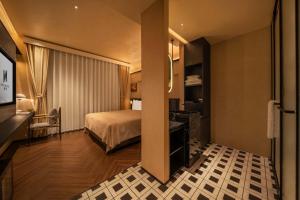 a hotel room with a bed and a television at PORTAL ART HOTEL in Fengjie