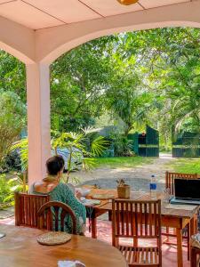 a person sitting at a table with a laptop at Haven Villa in Ahangama