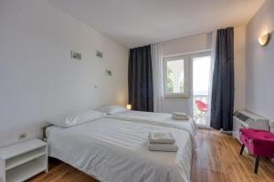 a bedroom with a white bed and a window at Martin's B&B in Dramalj