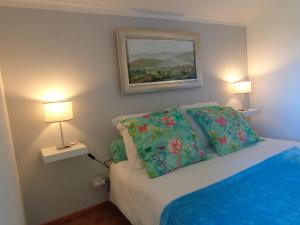 a bedroom with a bed with two lamps on it at Oak Cottage in Ferreira do Zêzere