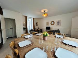 a dining room with a table and a living room at Casa Douce Angevine in Angers