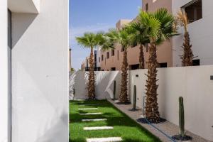 a pathway with palm trees in front of a building at Villa panorama Marrakech in Marrakesh